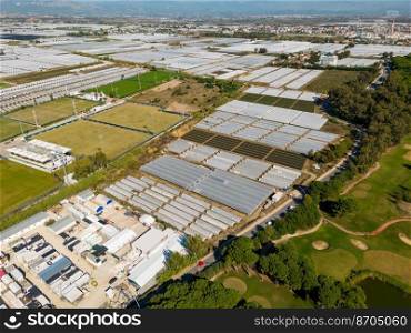 Aerial views of rows of greenhouses taken by drone. Greenhouse roofs background texture.
