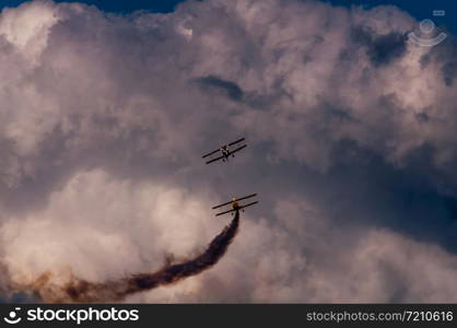 Aerobatics planes flying in the sky with clouds in the background