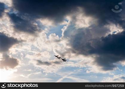 Aerobatics planes flying in the sky with clouds in the background