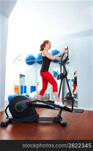 Aerobics cardio training woman on elliptic crosstrainer bicycle at gym