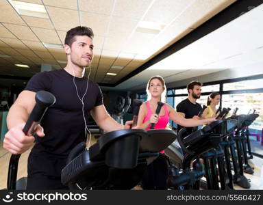 Aerobics elliptical walker trainer group at fitness gym workout