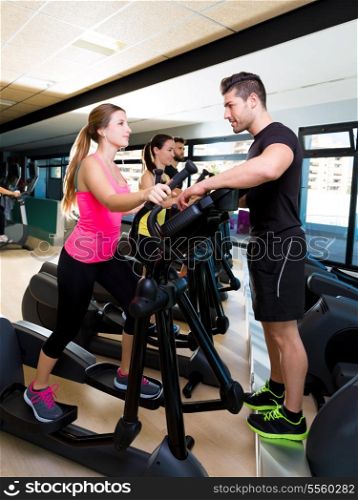 Aerobics elliptical walker trainer personal trainer man at fitness gym workout