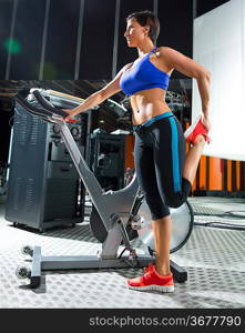 Aerobics spinning monitor trainer woman stretching exercises after workout at gym