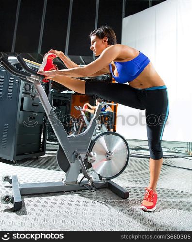 Aerobics spinning monitor trainer woman stretching exercises after workout at gym