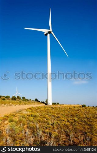 aerogenerator windmill in golden hill blue sky day