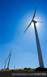 aerogenerator windmills in a row in blue sky day