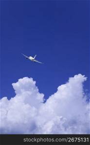Aeroplane gliding through a cloudy blue sky