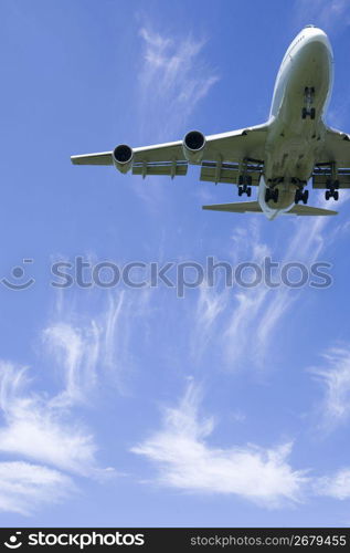 Aeroplane gliding through a cloudy blue sky