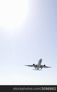 Aeroplane gliding through a cloudy white sky