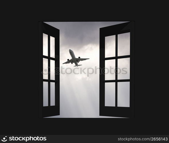 Aeroplane gliding through a sunset sky through a window frame