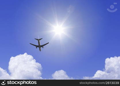 Aeroplane high in the sky with the sun shining brightly