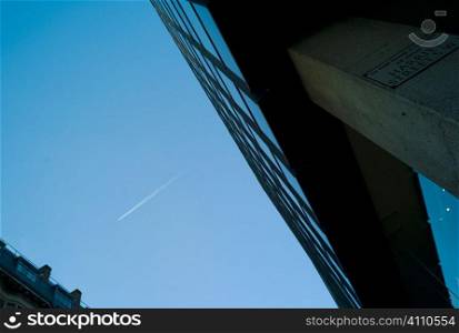 Aeroplane in sky above modern office building, Knightsbridge, London