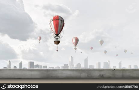 Aerostats flying over city. Colorful aerostats flying in clear sky above modern city