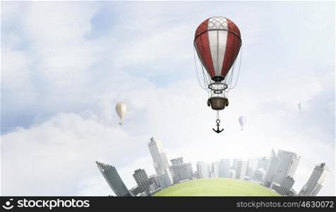 Aerostats flying over city. Colorful aerostats flying in clear sky above modern city
