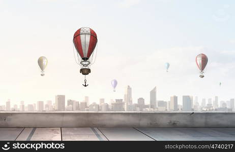 Aerostats flying over city. Colorful aerostats flying in clear sky above modern city