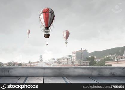 Aerostats flying over city. Colorful aerostats flying in clear sky above modern city