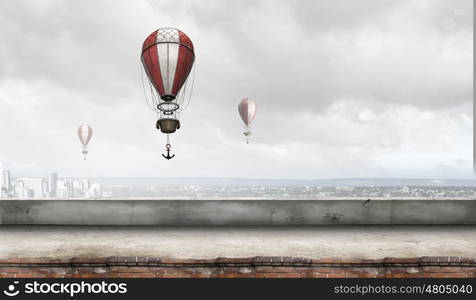 Aerostats flying over city. Colorful aerostats flying in clear sky above modern city