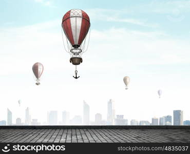 Aerostats flying over city. Colorful aerostats flying in clear sky above modern city