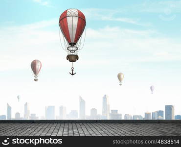 Aerostats flying over city. Colorful aerostats flying in clear sky above modern city