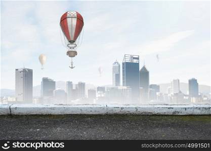 Aerostats flying over city. Colorful aerostats flying in clear sky above modern city