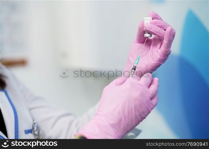 Aesthetic doctor preparing the syringe with the botulinum toxin to be injected in her patient.. Aesthetic doctor preparing the syringe with the botulinum toxin.