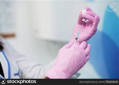 Aesthetic doctor preparing the syringe with the botulinum toxin to be injected in her patient.. Aesthetic doctor preparing the syringe with the botulinum toxin.