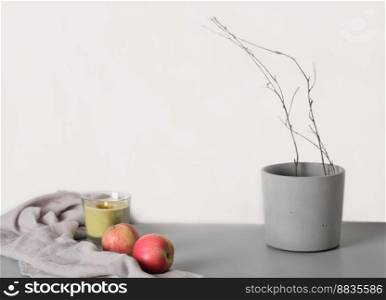 Aesthetic minimal hygge interior design concept. apples and cement flowerpot with tree branch on a grey background. copy space. Aesthetic minimal hygge interior design concept. apples and cement flowerpot with tree branch on a grey background. copy space.