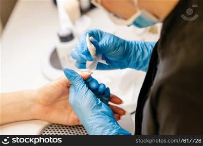 Aesthetician doing the manicure, filing the nails with a file to his client in a beauty center. Business and beauty concepts. Aesthetician doing the manicure, filing the nails with a file to his client in a beauty center