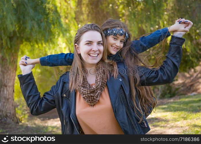 Affectionate Caucasian Mother and Mixed Race Daughter Portrait Outdoors.