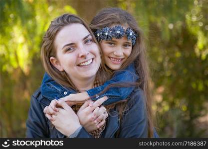 Affectionate Caucasian Mother and Mixed Race Daughter Portrait Outdoors.