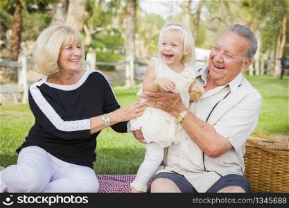 Affectionate Granddaughter and Grandparents Playing Outside At The Park.