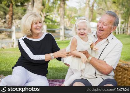 Affectionate Granddaughter and Grandparents Playing Outside At The Park.