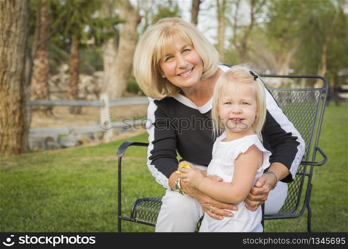 Affectionate Grandmother and Granddaughter Playing Outside At The Park.
