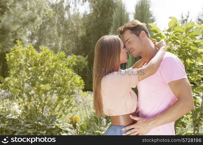 Affectionate young couple about to kiss in park