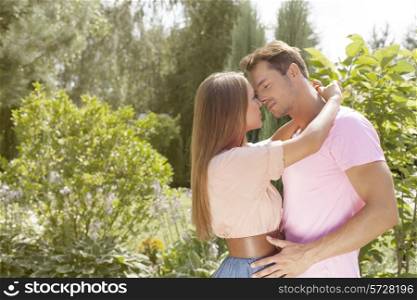 Affectionate young couple about to kiss in park