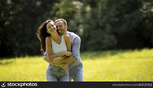 Affectionate young couple having fun on the green grass at the park