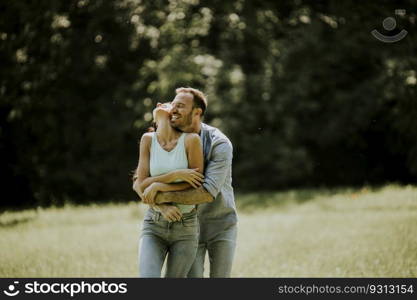 Affectionate young couple having fun on the green grass at the park