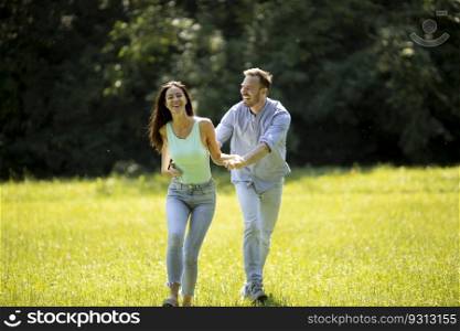 Affectionate young couple having fun on the green grass at the park