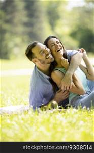Affectionate young couple sitting on the green grass at the park