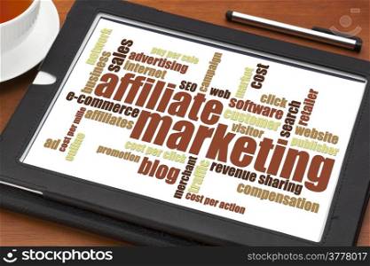 affiliate marketing word cloud on a digital tablet with a cup of tea