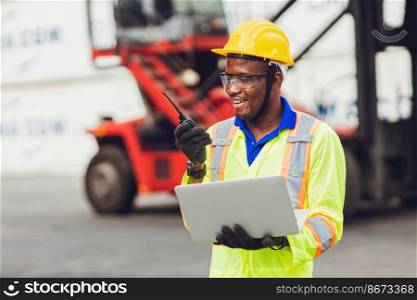 African American black worker working in logistic shipping cargo port site happy work control loading with radio and laptop.