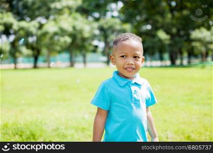 African American boy smiling in the park during summer