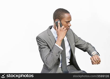 African American businessman checking time while on a call