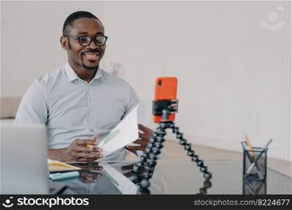 African american businessman discussing business project, communicating by video call, using smartphone. Smiling black man business coach conducts learning webinar or consulting client online.. African american businessman, business coach conducts online webinar by video call, using smartphone