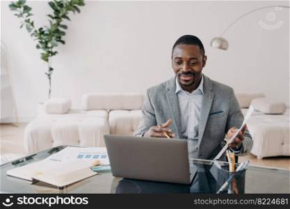African american businessman holding document paper report discuss working project online by video call at laptop. Smiling black male manager consulting client remotely. Remote work concept.. African american businessman holding document discuss working project online by video call at laptop