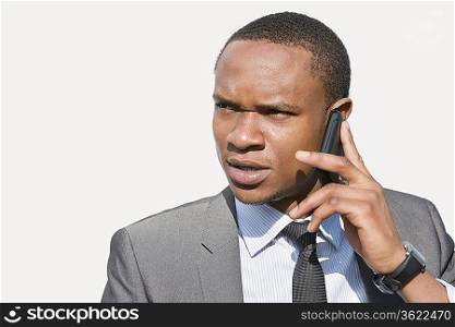 African American businessman looking away while talking on cell phone