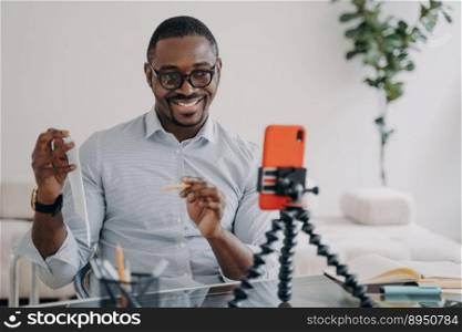 African american businessman presenting financial statistics by business corporate video call, using phone. Smiling friendly black male business coach teaching distantly online, showing document.. Smiling african american businessman presenting business data online by video call, using smartphone