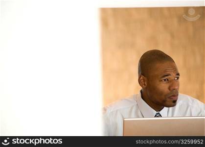African- American businessman working on laptop.