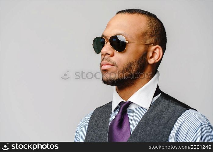 African-American businessmanman wearing glasses portrait over grey background.. African-American businessmanman wearing glasses portrait over grey background