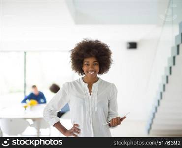 african american Businesswoman using tablet with coworkers in backgorund having meeting